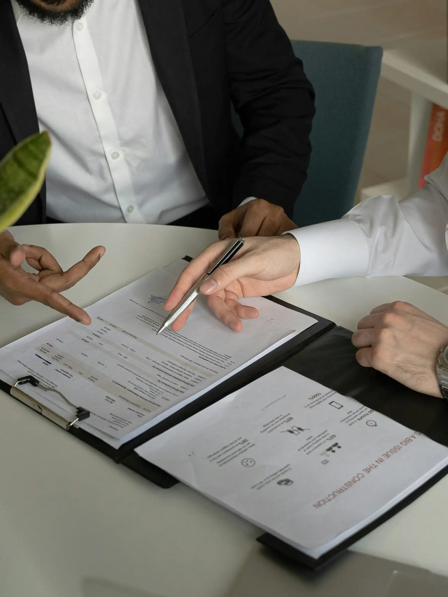 Two people reviewing contract documents at a desk