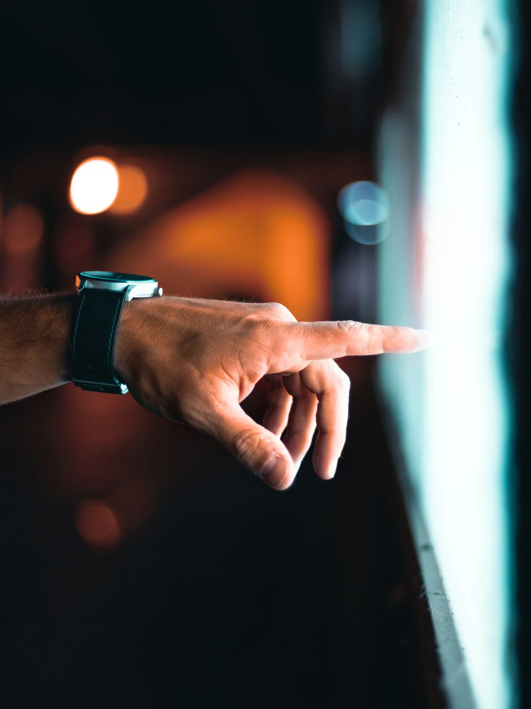 A hand touching a screen showing a digital interface